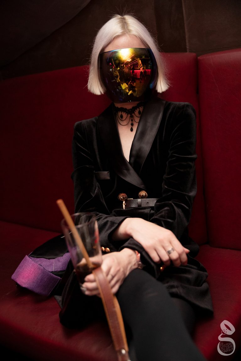 Portrait de Madame Toska, maitresse dominatrice BDSM à Paris tenant la laisse de son esclave aux Gouters du Divin Marquis.