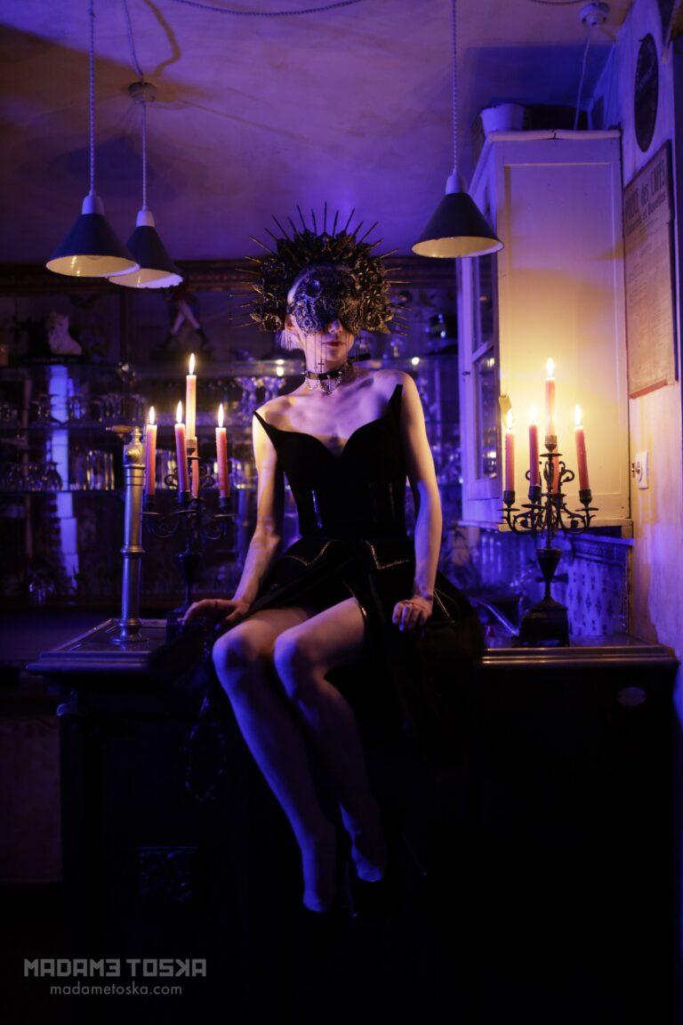La dominatrice parisienne Madame Toska offre sa beauté au photographe en étant assise sur un bar.
