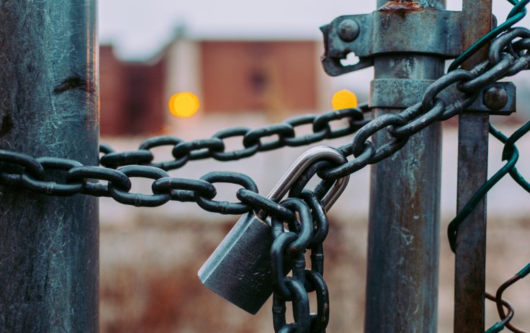 Une porte fermée par un cadenas pour symboliser un énis enfermé en cage de chasteté